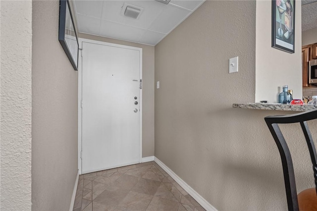 entryway featuring baseboards and light tile patterned flooring