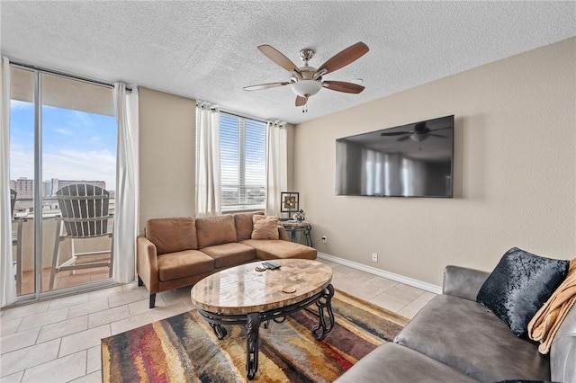 tiled living room with a textured ceiling, ceiling fan, and baseboards