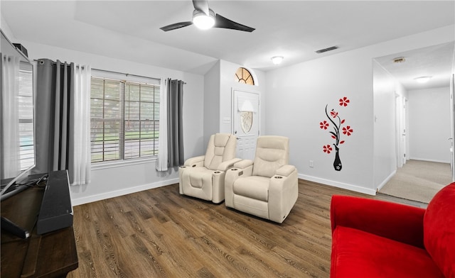 living area with ceiling fan and dark hardwood / wood-style flooring