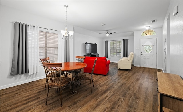 dining area with dark hardwood / wood-style flooring and ceiling fan with notable chandelier