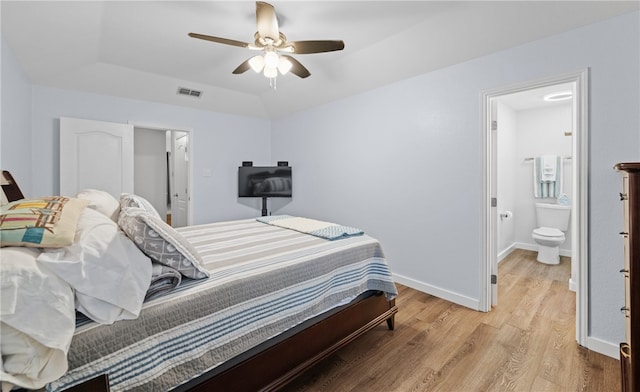 bedroom with ensuite bathroom, light hardwood / wood-style floors, and ceiling fan