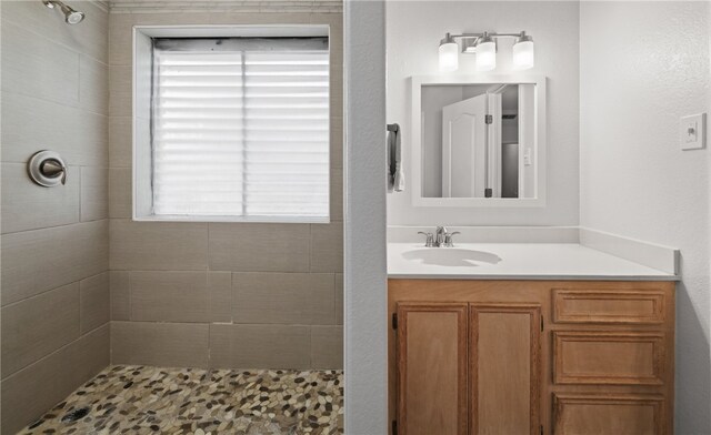 bathroom featuring vanity and tiled shower