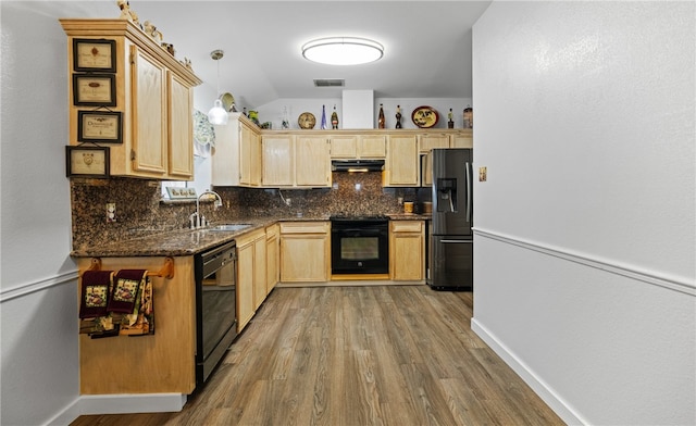 kitchen with black appliances, dark stone counters, light hardwood / wood-style flooring, lofted ceiling, and decorative backsplash