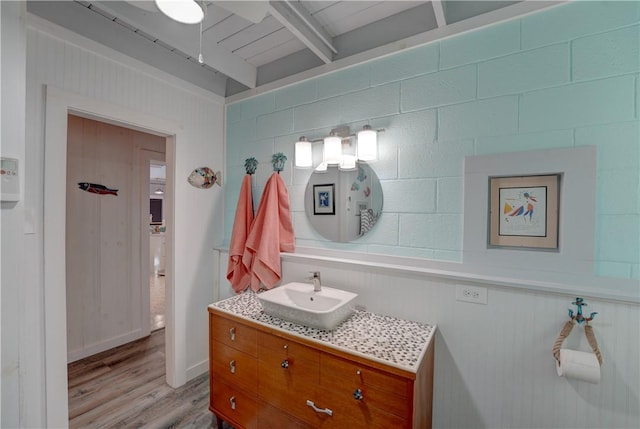 bathroom featuring beamed ceiling, vanity, and wood-type flooring