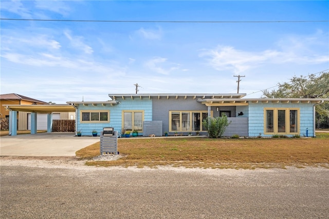 ranch-style home featuring a carport and a front yard