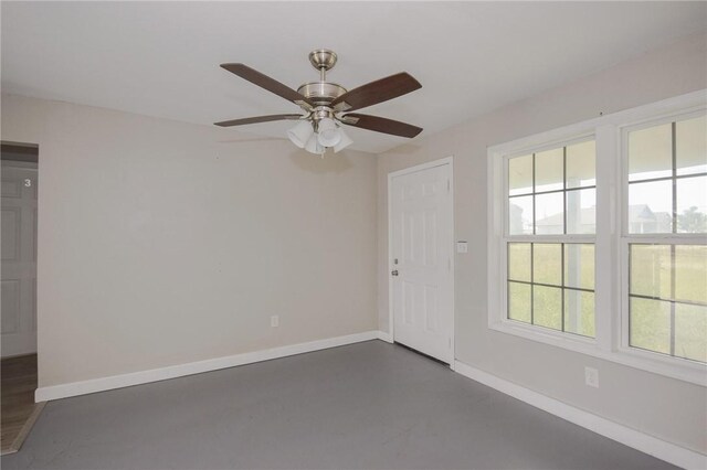105 E Cornwall St, Rockport, TX 78382 - empty room with healthy amount of natural light, baseboards, a ceiling fan, and finished concrete floors