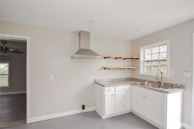 105 E Cornwall St, Rockport, TX 78382 - kitchen with wall chimney exhaust hood, a sink, baseboards, white cabinets, and light countertops
