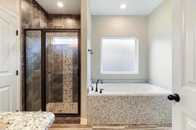 full bathroom featuring a garden tub, recessed lighting, wood finished floors, and a shower stall