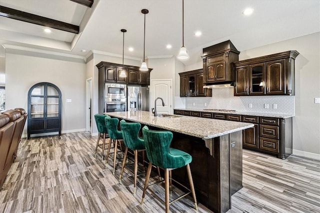 kitchen with decorative backsplash, a breakfast bar, baseboards, a sink, and stainless steel appliances
