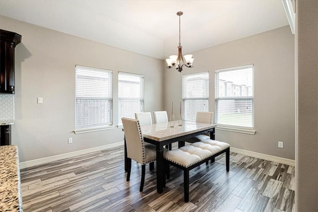 dining area featuring baseboards, a notable chandelier, a wealth of natural light, and light wood-style floors
