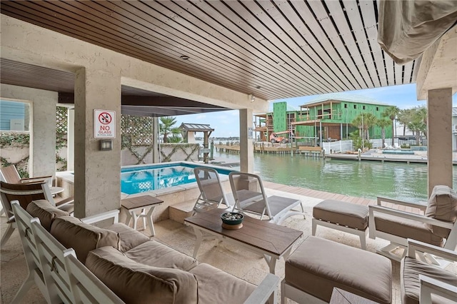 view of pool with an outdoor living space and a water view