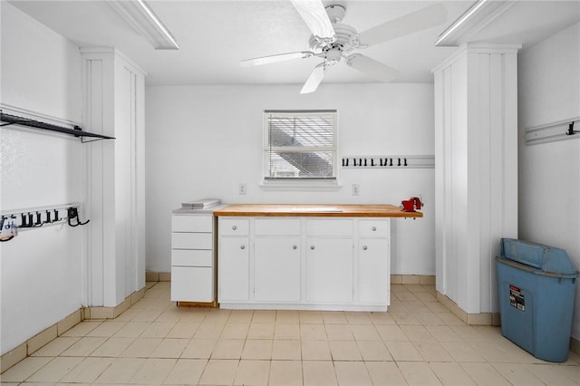 kitchen featuring white cabinets, butcher block counters, and ceiling fan