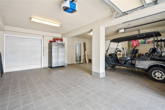 garage with a garage door opener and freestanding refrigerator