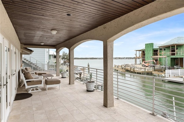 view of patio / terrace with a balcony and a water view