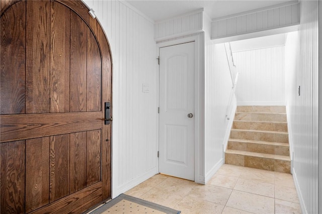 entrance foyer featuring stairway and light tile patterned flooring