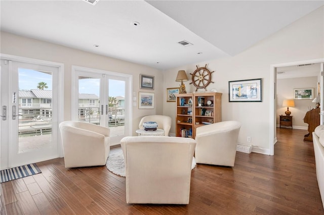 living area featuring visible vents, french doors, baseboards, and wood finished floors