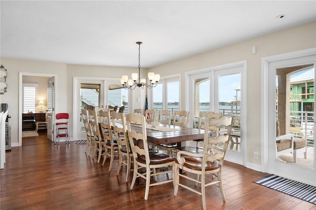 dining room featuring a wealth of natural light, an inviting chandelier, and dark wood-style floors