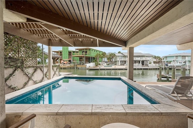 view of swimming pool with a water view and a boat dock