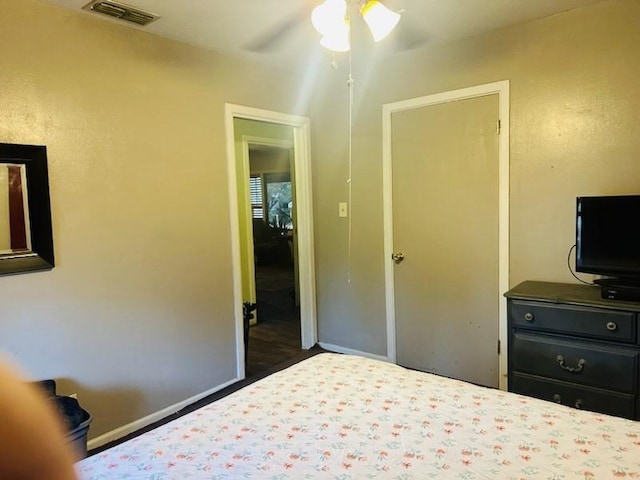 bedroom with dark hardwood / wood-style floors and ceiling fan