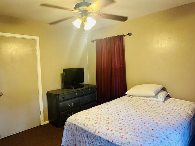 bedroom featuring dark colored carpet and ceiling fan