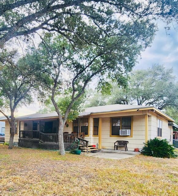 rear view of house featuring cooling unit, a yard, and a patio