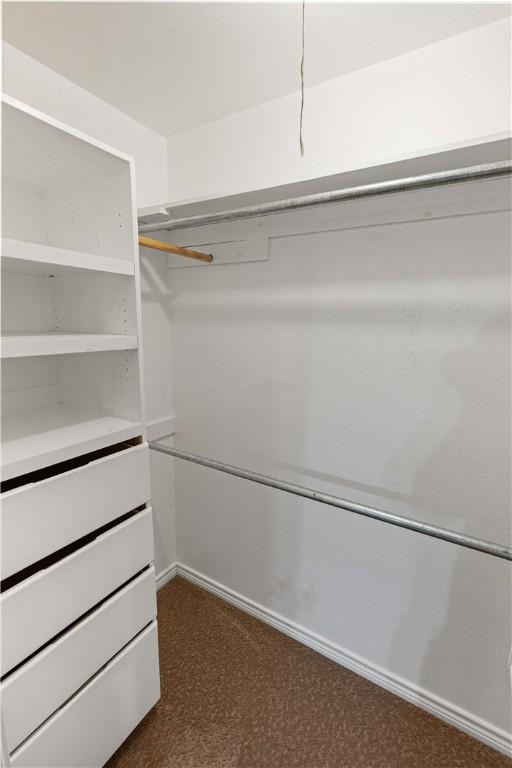 spacious closet featuring dark carpet