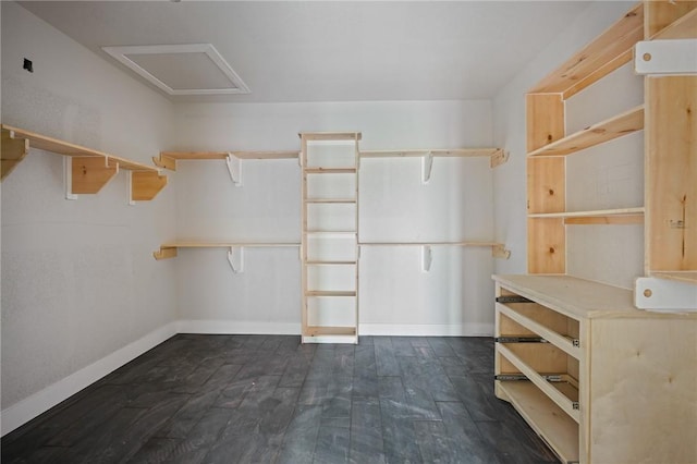 walk in closet with dark wood-style floors and attic access