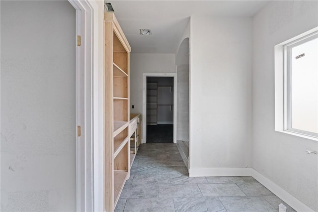 interior space featuring arched walkways and baseboards