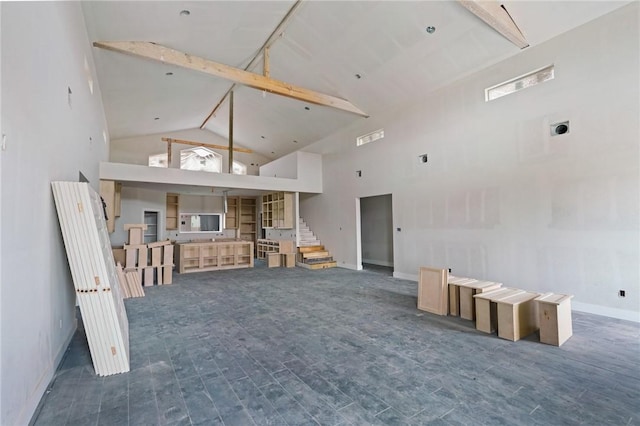 unfurnished living room with high vaulted ceiling, wood finished floors, beamed ceiling, and stairs