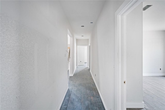 corridor featuring baseboards and hardwood / wood-style floors