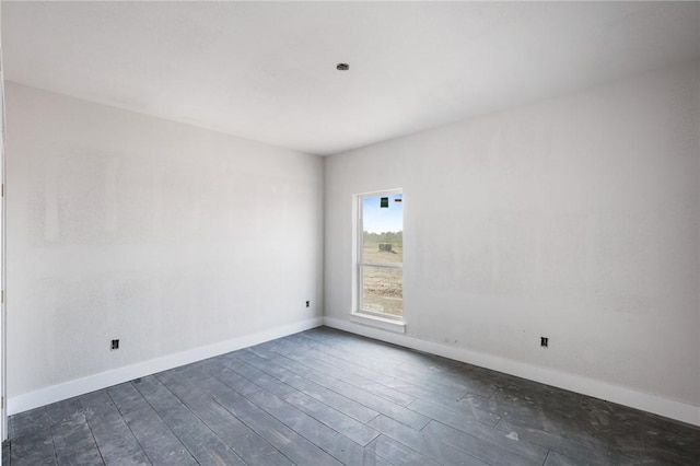 empty room with dark wood-style floors and baseboards