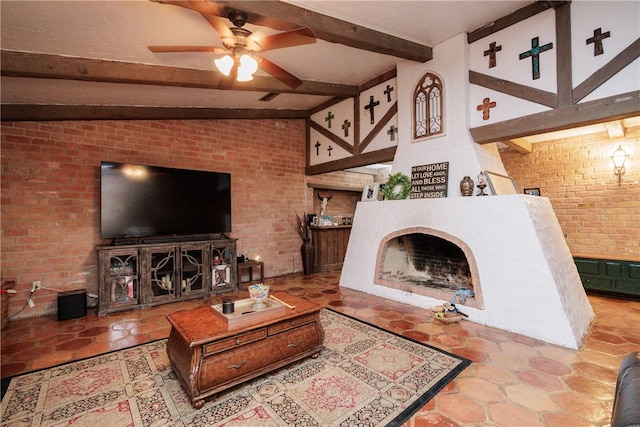 living room with vaulted ceiling with beams, a large fireplace, ceiling fan, and brick wall