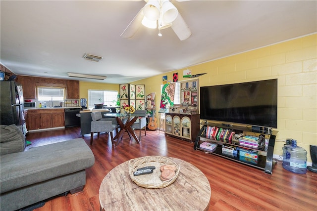 living room with wood-type flooring, ceiling fan, and sink