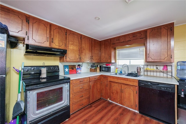 kitchen featuring black appliances, sink, and dark hardwood / wood-style floors