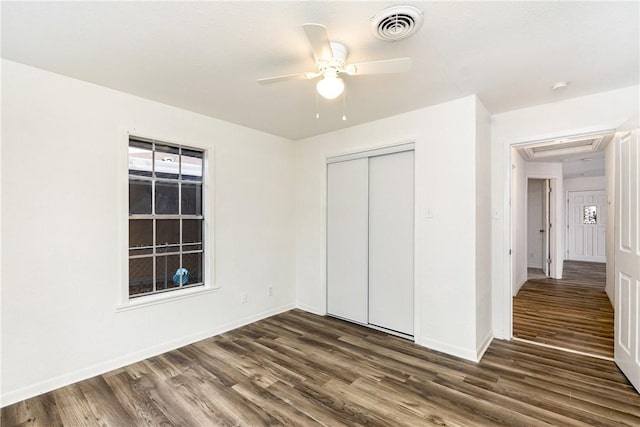 unfurnished bedroom with ceiling fan, a closet, and dark hardwood / wood-style flooring