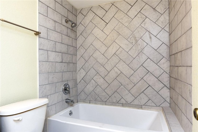 bathroom with toilet and tiled shower / bath