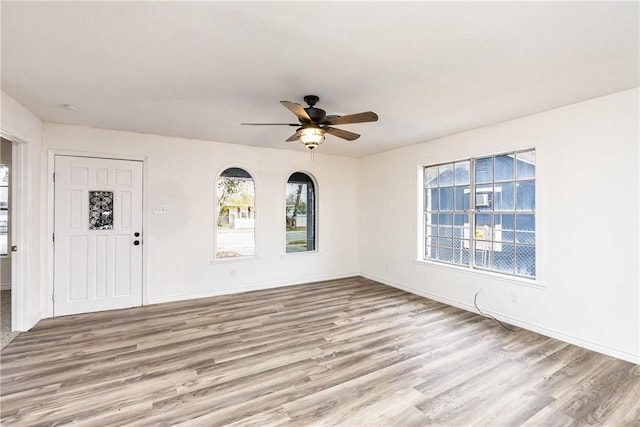 empty room with ceiling fan and light wood-type flooring