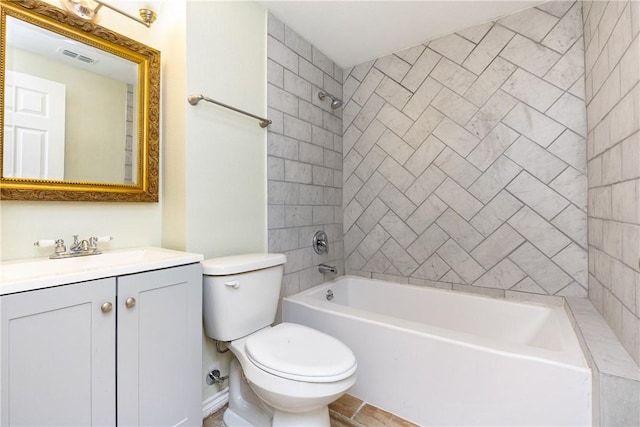 full bathroom featuring tiled shower / bath combo, vanity, and toilet