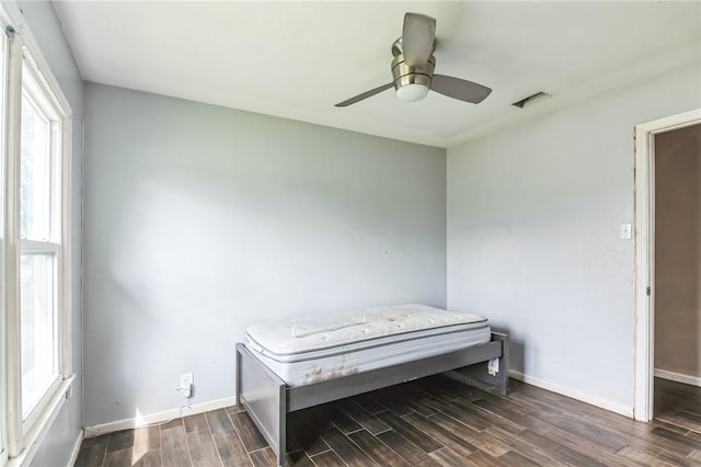 bedroom featuring wood tiled floor, multiple windows, and baseboards