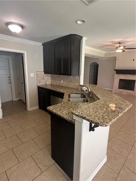 2818 Lake Rhapsody Dr, Corpus Christi, TX 78414 - kitchen featuring ceiling fan, light tile patterned floors, a peninsula, ornamental molding, and light stone counters
