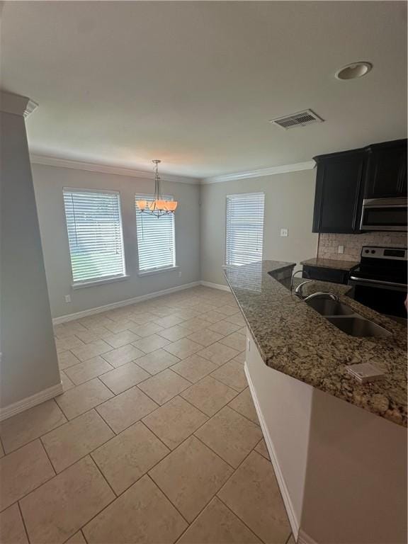 2818 Lake Rhapsody Dr, Corpus Christi, TX 78414 - kitchen featuring appliances with stainless steel finishes, dark cabinetry, crown molding, stone countertops, and plenty of natural light