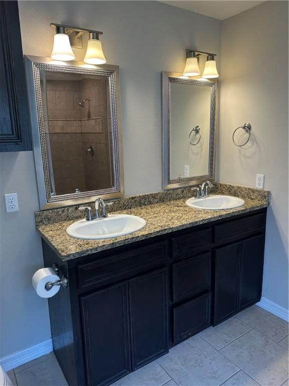 2818 Lake Rhapsody Dr, Corpus Christi, TX 78414 - bathroom featuring double vanity, a tile shower, and tile patterned flooring