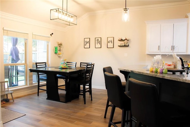 6834 Boardwalk Ave, Corpus Christi, TX 78414 - dining room featuring ornamental molding, light wood finished floors, vaulted ceiling, and baseboards