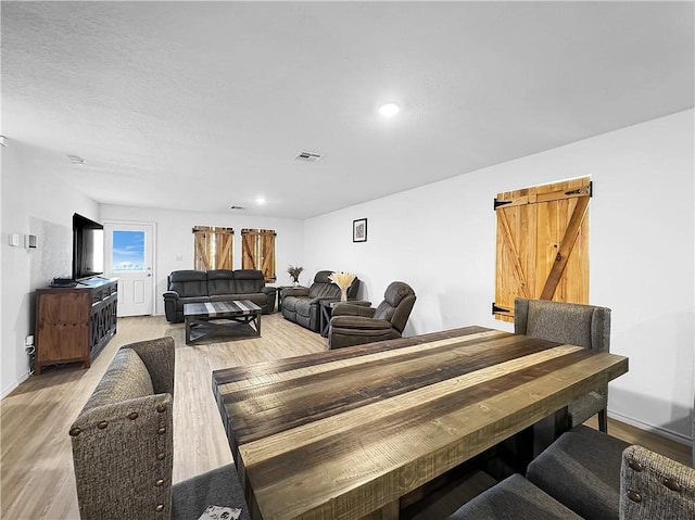 interior space with a barn door and wood-type flooring