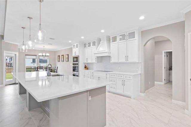 kitchen featuring a large island, custom exhaust hood, pendant lighting, white cabinets, and sink