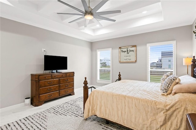 bedroom with a raised ceiling and ceiling fan