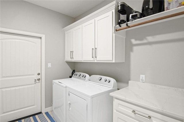 laundry room with washer and dryer and cabinets