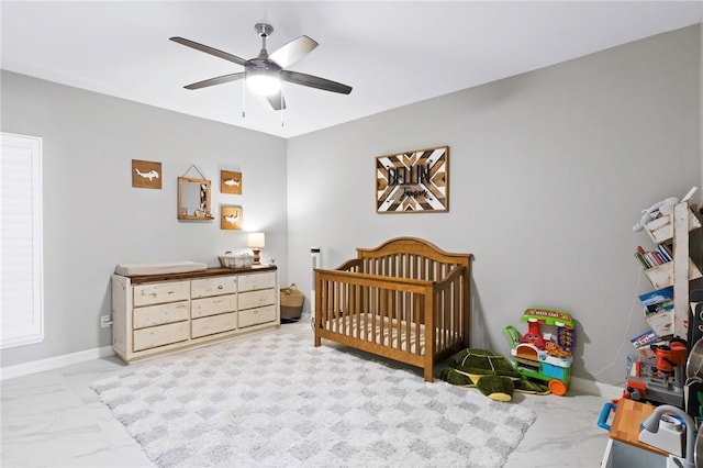 bedroom with a nursery area and ceiling fan