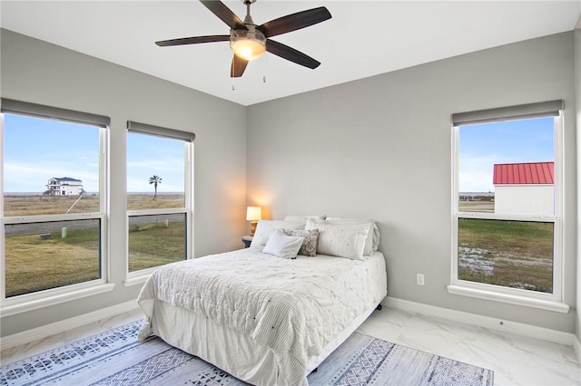 bedroom with ceiling fan and multiple windows