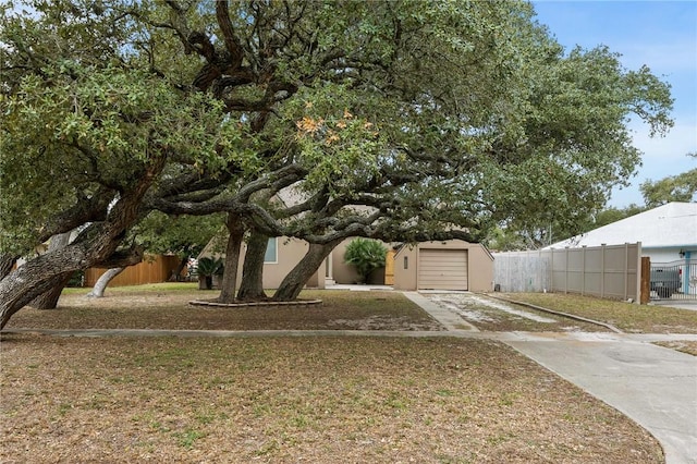 view of yard featuring driveway, an attached garage, and fence